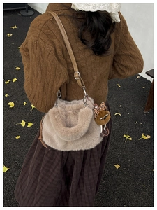 Detail view of winter plush crossbody bag with leopard bow bear pendant and fuzzy texture