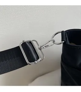 Close-up of high-quality silver metal hook and strap adjuster on a black tote bag