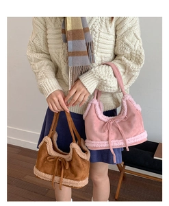 Detail of plush faux shearling trim and suede bow on chic autumn winter tote bag