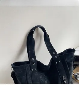 Detail of comfortable shoulder strap with metal eyelets on a black matte tote bag