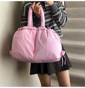 Detailed view of pink puffer bucket bag with drawstring closure and padded handle