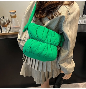 Detail of bright green puffer cloud bag with quilted texture and knotted shoulder strap