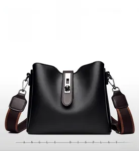 Vue de face du sac seau noir avec sangle en cuir marron et boucle en métal argenté