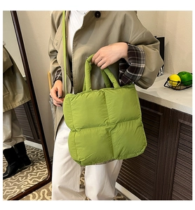 Green quilted puffer bag with crossbody strap and double handles in soft padded style