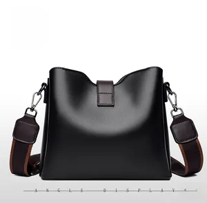 Vue arrière du sac seau en cuir noir avec une large bandoulière tissée marron et beige