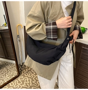 Crossbody black crescent moon bag shown on model for size and casual style reference