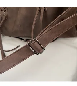 Detail of adjustable strap with matte metal buckle and stitching on vintage suede bag