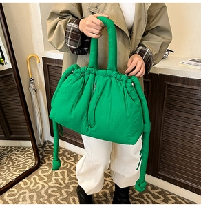 Macro detail of vibrant green quilted nylon bucket bag with padded handle and drawstrings