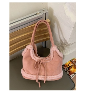 Detail of pink faux suede tote bag with plush fleece trim and a decorative bow design
