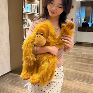 Detailed close-up of a long-haired golden gorilla plush toy held by a model for size display