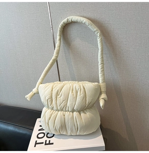 Detailed view of the creamy white quilted puff shoulder bag with soft pleated texture