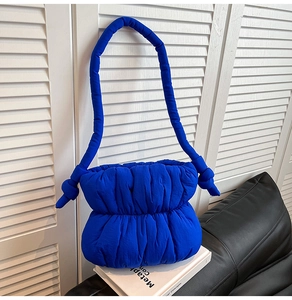 Detail of royal blue quilted puff bag with textured ruched fabric and thick knot strap