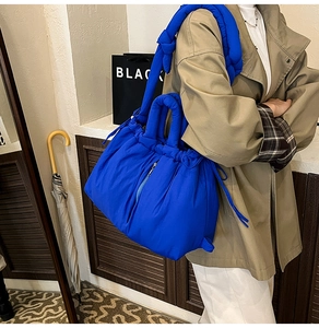 Detail of Klein blue padded bucket bag with knotted strap and side drawstring closure