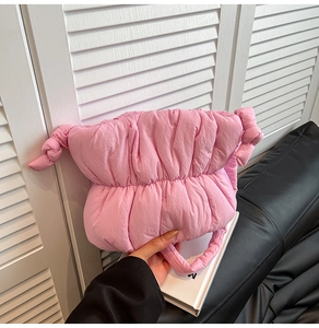 Detailed shot of pink quilted cloud bag featuring soft padded texture and knot details