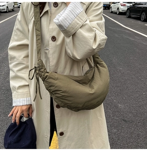 Olive green pleated crescent bag showing adjustable shoulder strap and drawstring details