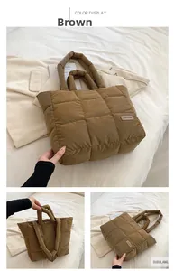 Detail of a brown quilted puffer tote bag featuring a leather Fashion tag and soft texture