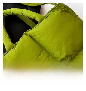 Close-up of vibrant green quilted tote bag showing padded handles and stitching detail