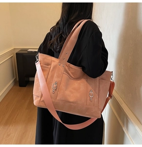 Pink tote bag detail showing adjustable wide shoulder strap and silver metal hardware