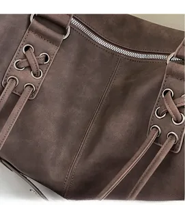 Macro shot of brown frosted faux leather texture with silver metal zipper and eyelet detail