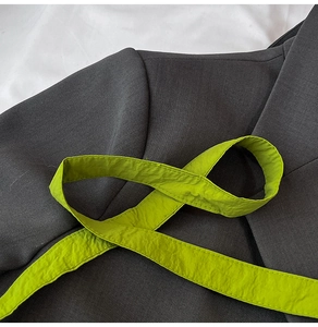 Close-up of charcoal grey twill jacket featuring a vibrant neon green textured drawstring