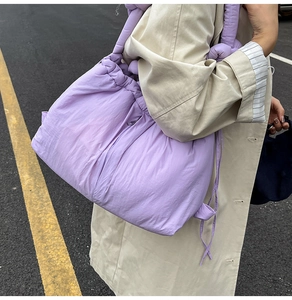 Detail view of light purple quilted bucket bag with drawstring and padded shoulder strap