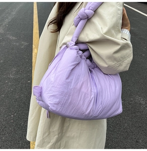 Close-up of lilac puffy nylon bucket bag featuring a unique knotted shoulder strap detail