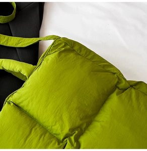 Close-up of bright green quilted padded handbag showing nylon texture and stitching