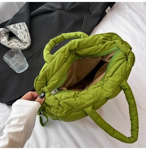 Detail view of the grass green quilted puffer tote bag with secure zipper and brown lining