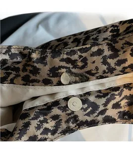 Close-up of leopard print canvas tote bag featuring a secure silver magnetic buckle closure