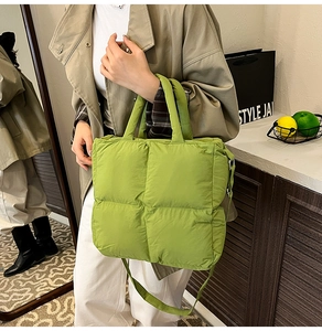 Macro detail of the green quilted puffer bag showing premium padded nylon texture and seams