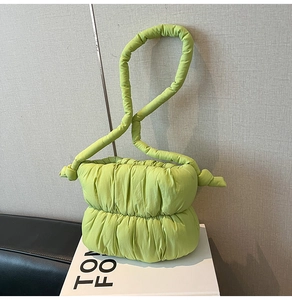 Detail of quilted cloud bag in neon green featuring soft padded knot and texture