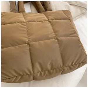 Detail of quilted puffer tote bag with brown fabric and soft padded shoulder straps