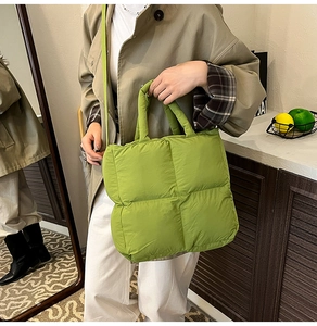 Detail of avocado green quilted puffer bag featuring soft padded square texture and strap
