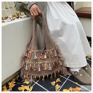 Detail of knitted tote bag featuring multi-color fringe and golden woven trim accents