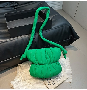 Detail of green puffy cloud bag with quilted padding and soft crossbody shoulder strap