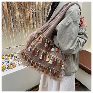 Detail of bohemian knit tote bag featuring colorful fringe and handcrafted textures