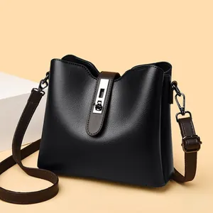 Détail du sac seau noir avec boucle en métal argenté et bandoulière marron réglable