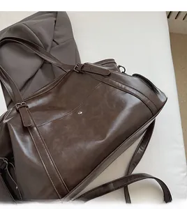 Détail de la bandoulière à boucle réglable sur le cabas rétro en cuir PU brun