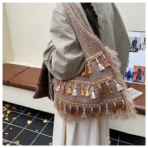Detail of bohemian knit tote bag showing intricate fringe and feather-like fur trim textures