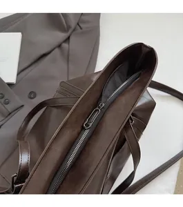 Détail de la fermeture éclair en métal et de la doublure de ce grand sac cabas en cuir brun