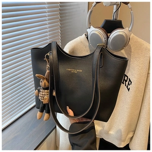 Close-up of black leather tote bag with gold lettering and a cute rabbit charm detail