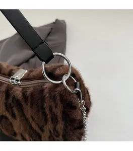 Close-up of leopard faux fur texture and polished silver metal hardware on luxury bag