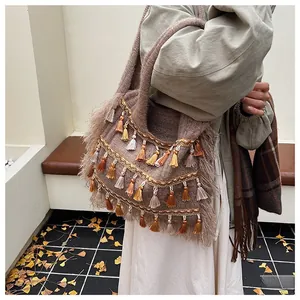 Close-up of bohemian knit tote bag with colorful tassels and intricate embroidery detail