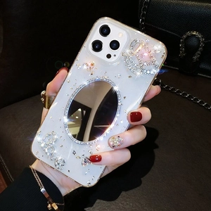 Close-up of luxury phone case featuring rhinestones, crown detail and rear mirror