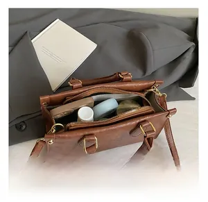 Detail view of the brown leather bag interior showing spacious compartments and zipper pocket