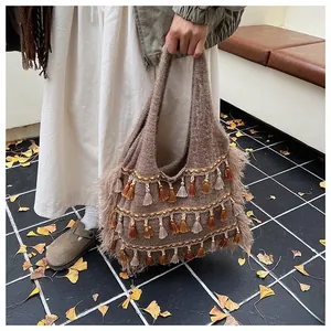 Detail of knitted tote bag with retro fringes and earthy tones in an autumn setting