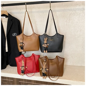 Close-up of matte leather tote bags in four colors with cute plush rabbit charms