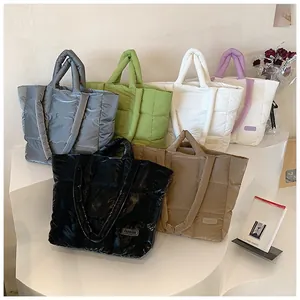 Multiple colors of quilted down tote bags with Fashion labels on minimalist display