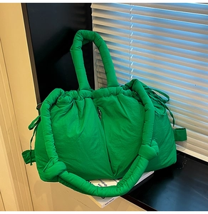 Detail of bright green quilted puffer tote bag with drawstring closure and soft handles