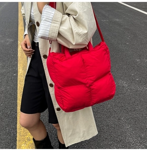 Close-up of bright red quilted puffer tote bag with premium stitched grid texture